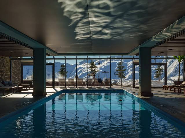 Indendørs pool og spa på hotellet med panoramavinduer ud mod sne og bjerge